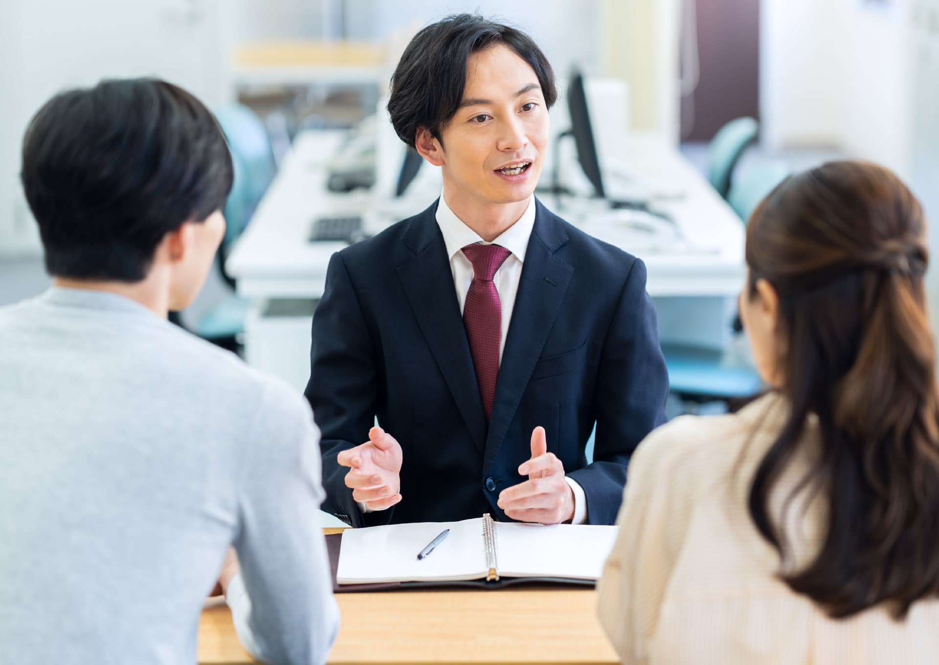 夫婦に説明するセールスマン